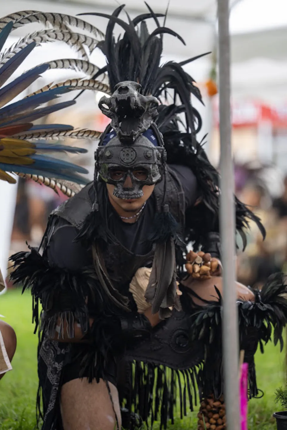 A dancer wears an animal-skull headdress and skeletal face paint